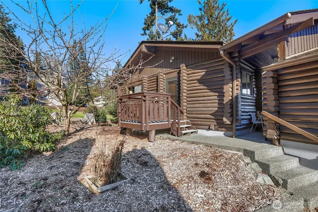 a view of a house with a yard chairs and wooden fence