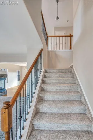 a view of a livingroom with a fireplace a ceiling fan and wooden floor
