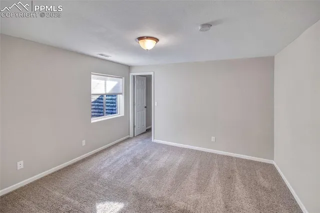 an empty room with windows and ceiling fan