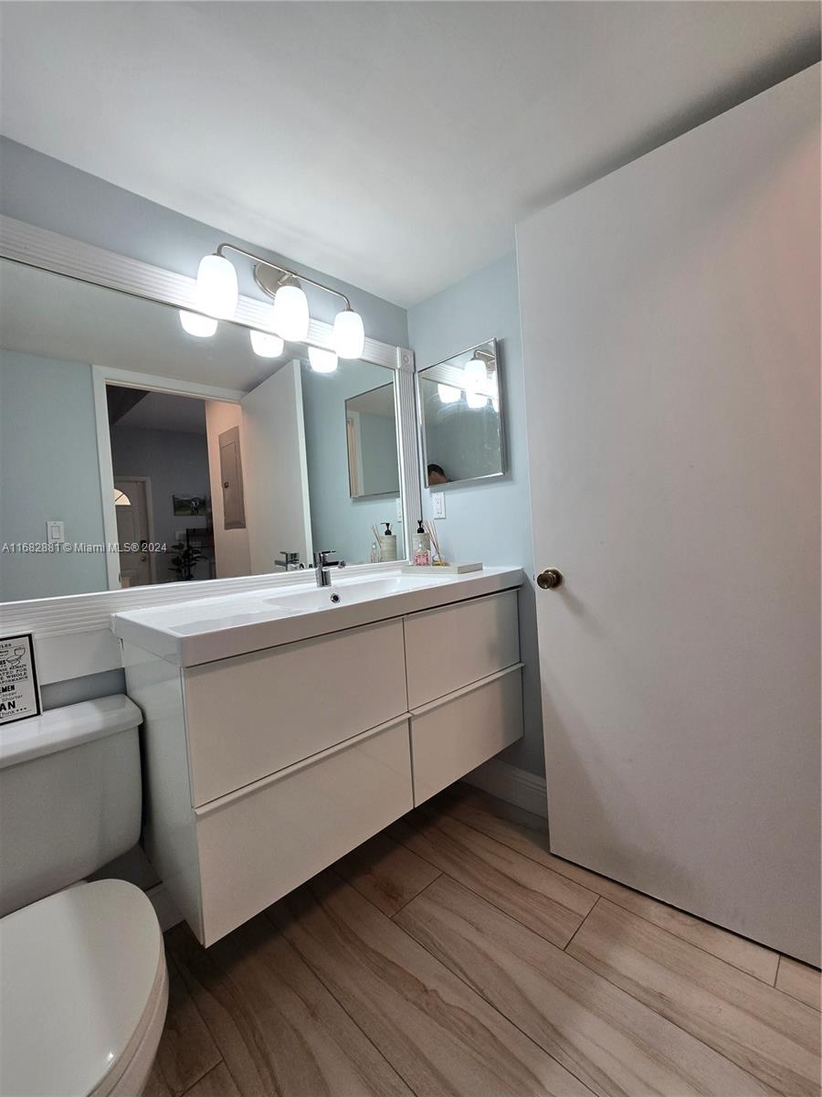 537 Racquet Club Road, Unit 37 Weston, FL 33326 - Photo 11 of 24 a bathroom with a toilet sink and mirror