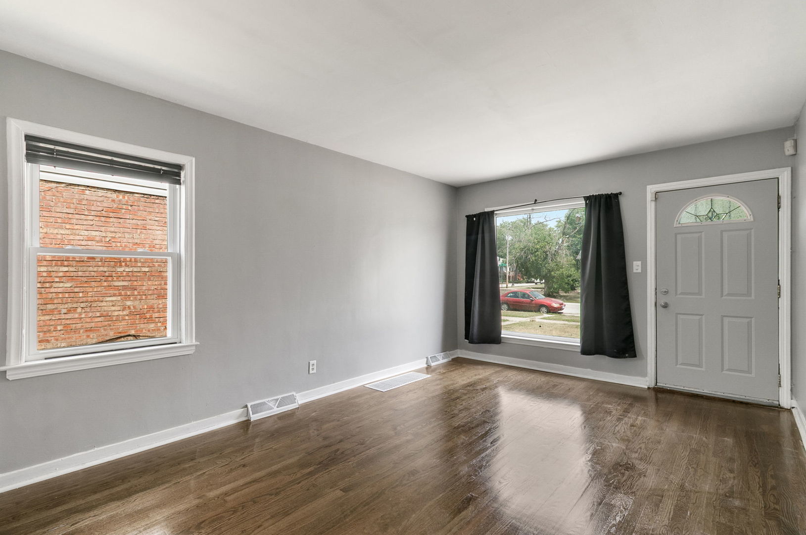 1532 State Line Road Calumet City, IL 60409 - Photo 4 of 15 a view of an empty room with wooden floor and a window