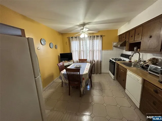 a kitchen with stainless steel appliances granite countertop sink stove top oven and cabinets