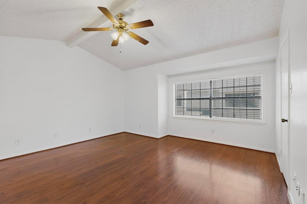 8545 Midpark Road, Unit 16 Dallas, TX 75240 - Photo 20 of 29 Spare room with a textured ceiling, beam ceiling, ceiling fan, and dark wood-style flooring