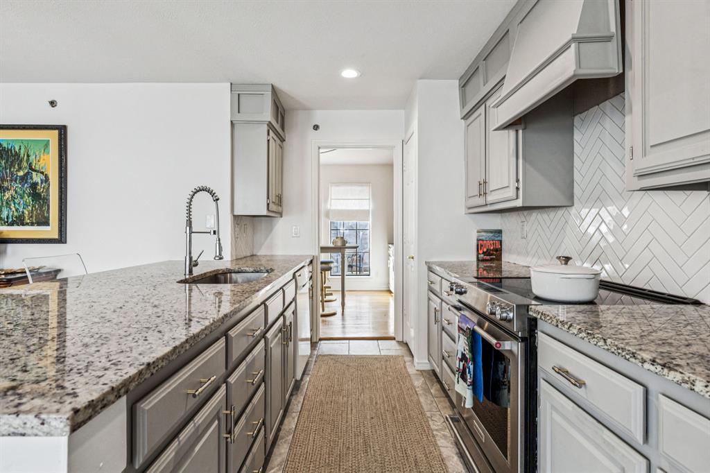 3635 Bryan Street Dallas, TX 75204 - Photo 16 of 40 a kitchen with granite countertop a sink stove and cabinets