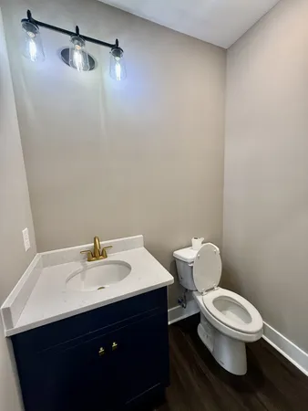 a bathroom with a toilet a sink and mirror