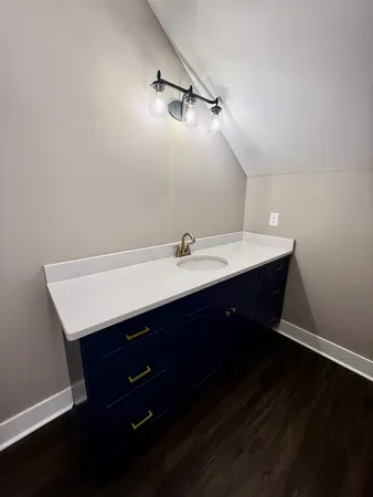 an empty room with wooden floor a ceiling fan and windows