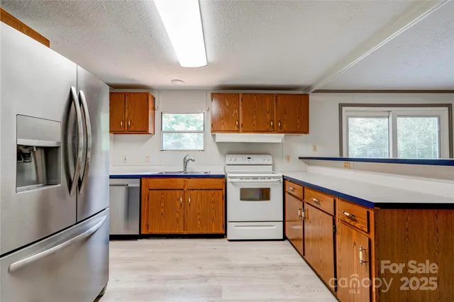 a kitchen with stainless steel appliances granite countertop a refrigerator sink and stove