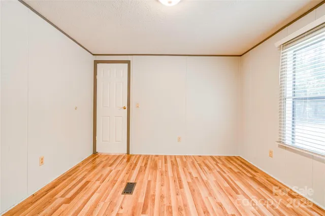 a view of a room with wooden floor and white walls
