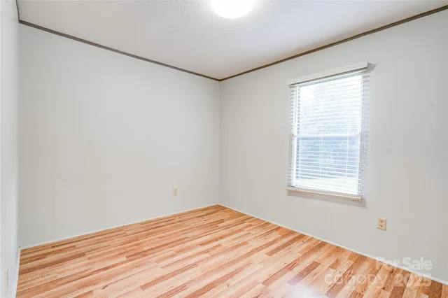 a view of a room with wooden floor and white walls