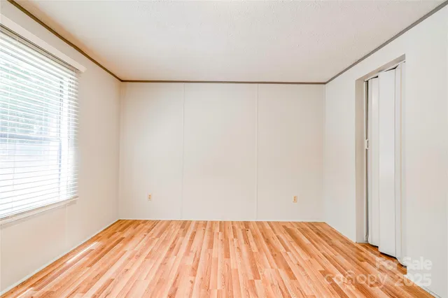 a view of a room with wooden floor and small window