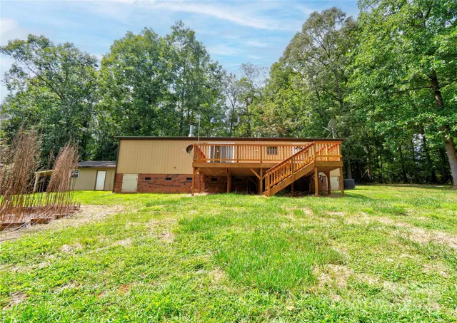 a backyard of a house with wooden fence and large trees