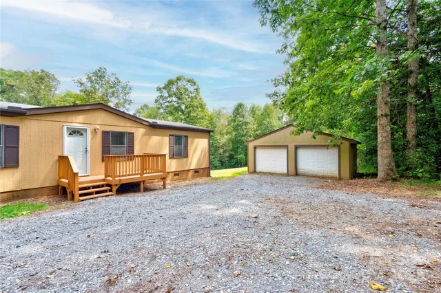 a view of a house with a yard and large tree