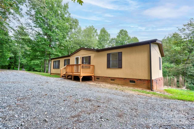 a view of a house with a backyard and a tree