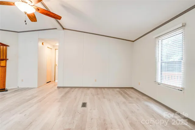 an empty room with a window and wooden floor