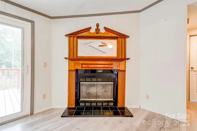 a living room with a fireplace a rug and a window