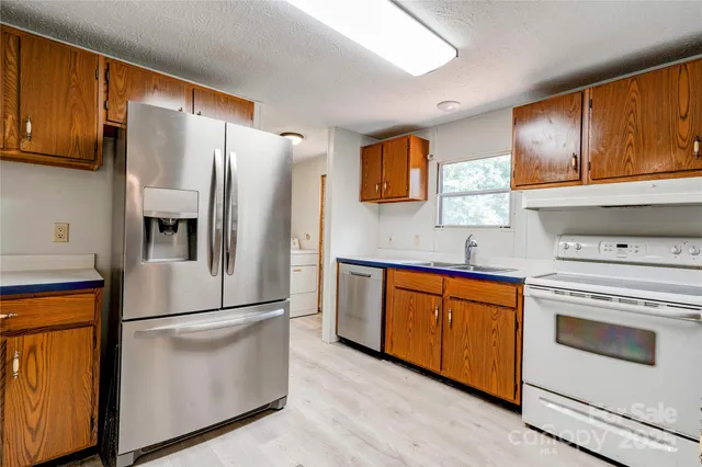 a kitchen with stainless steel appliances granite countertop a refrigerator stove and sink