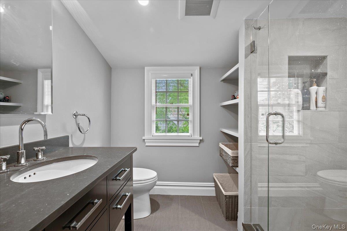 7 Harcourt Road Scarsdale, NY 10583 - Photo 25 of 34 a bathroom with a sink toilet a mirror and shower