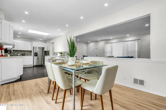 a dining area with furniture and a wooden floor