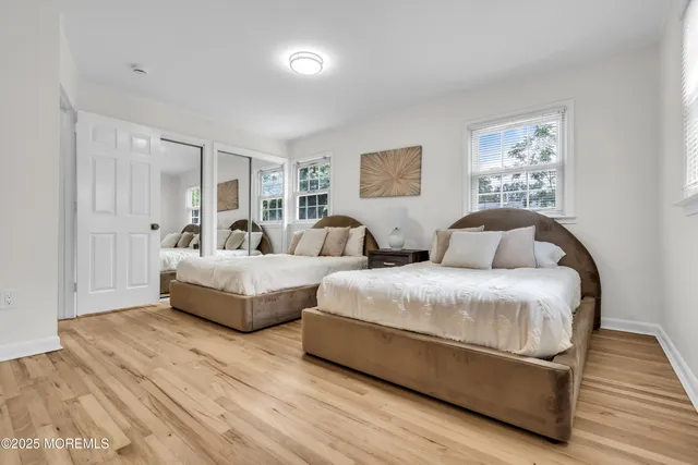 a spacious bedroom with two beds and painting on the wall