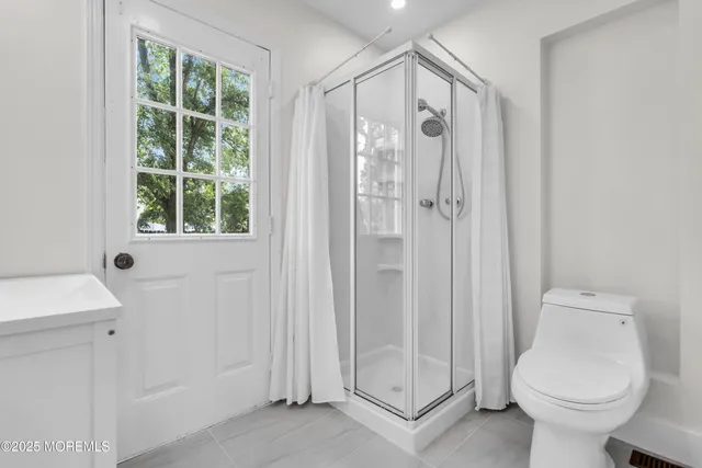 a bathroom with a shower a toilet and a sink