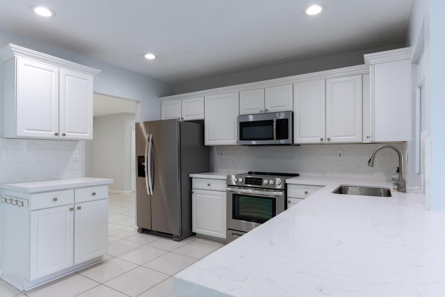 4695 Brandywine Drive Boca Raton, FL 33487 - Photo 7 of 28 a kitchen with stainless steel appliances granite countertop white cabinets and refrigerator