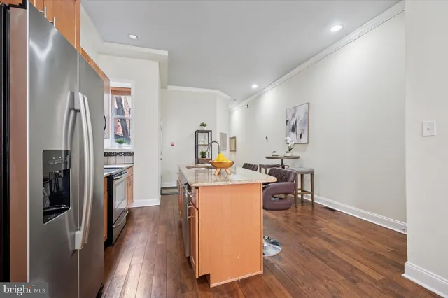 a view of a kitchen and dining area with wooden floor