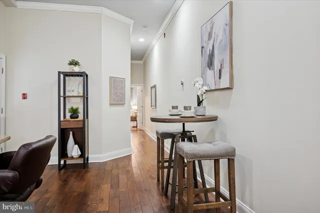 a view of a hallway with furniture and wooden floor