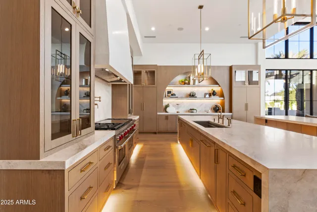 a large kitchen with kitchen island a large island a sink stainless steel appliances and windows