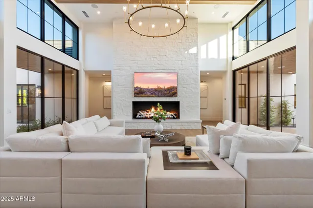 a living room with furniture chandelier and a large window