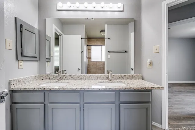 a bathroom with a granite countertop sink and a mirror
