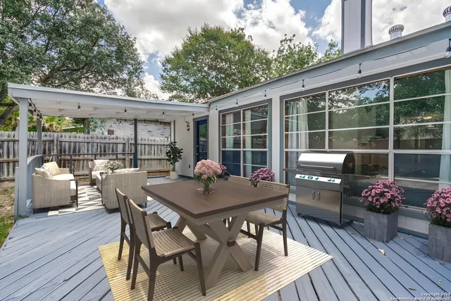 a view of a patio with a dining table and chairs with wooden floor