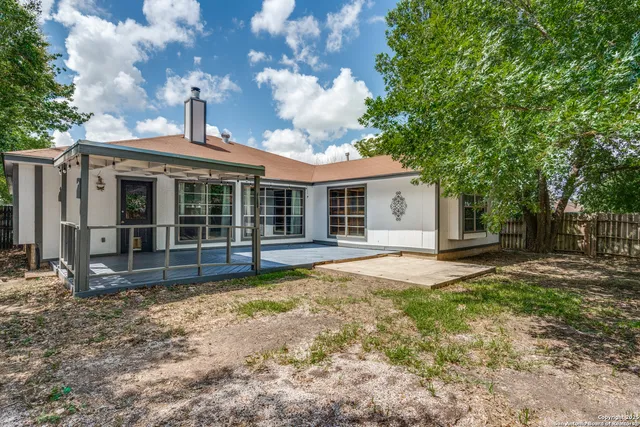 a view of a house with a yard and large tree