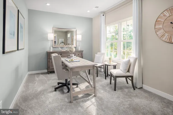 a work room with furniture a rug and a window