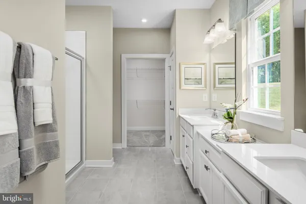 a spacious bathroom with a double vanity sink a large mirror a shower and a bathtub