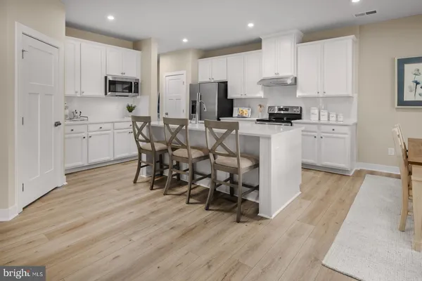 a kitchen with white cabinets and stainless steel appliances