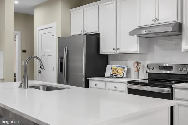 a kitchen with stainless steel appliances a sink a stove and refrigerator