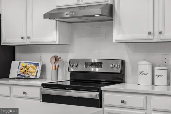 a stove top oven sitting inside of a kitchen