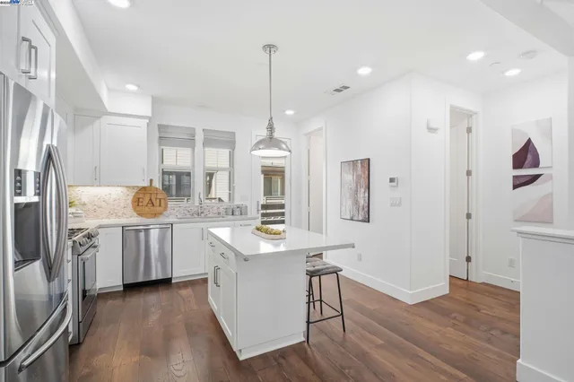 a kitchen with kitchen island white cabinets and stainless steel appliances