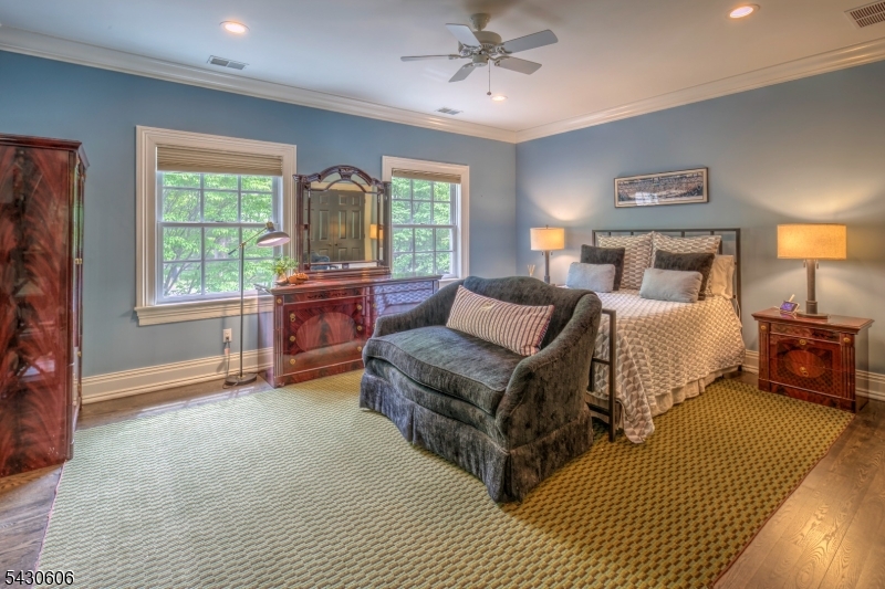 5 Burnett Road Mendham, NJ 07945 - Photo 29 of 50 a spacious bedroom with a bed a chandelier and a window