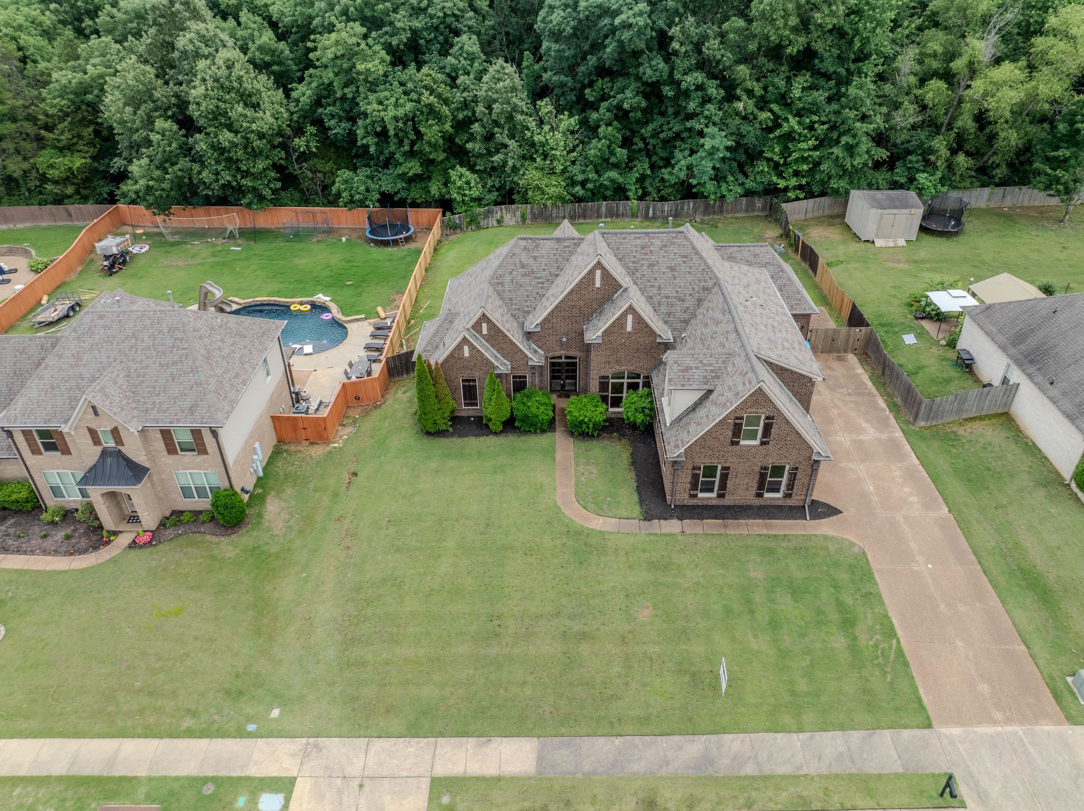 5380 Scarlet Ridge Drive Arlington, TN 38002 - Photo 26 of 35 Brick exterior with contrasting dark shutters, a multi-gabled roofline, and an attached two-car garage