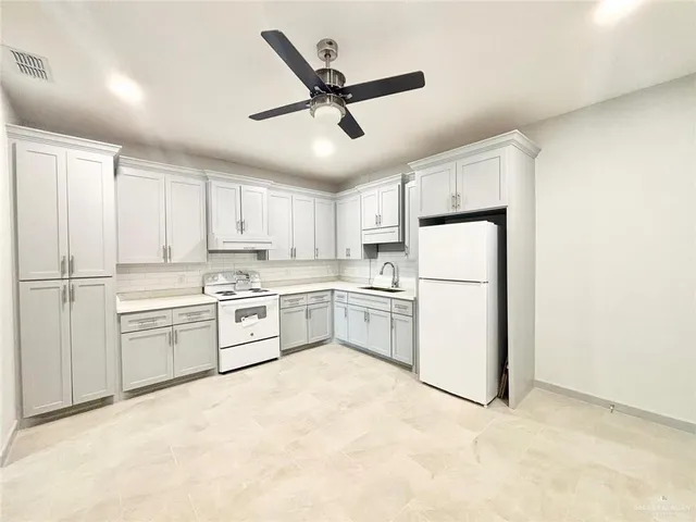 a kitchen with white cabinets and white appliances