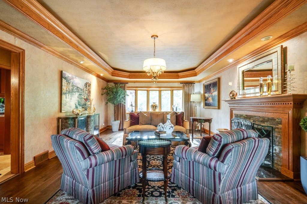 8465 Whitewood Road Brecksville, OH 44141 - Photo 2 of 13 Living room with a tray ceiling, crown molding, a chandelier, and hardwood / wood-style floors