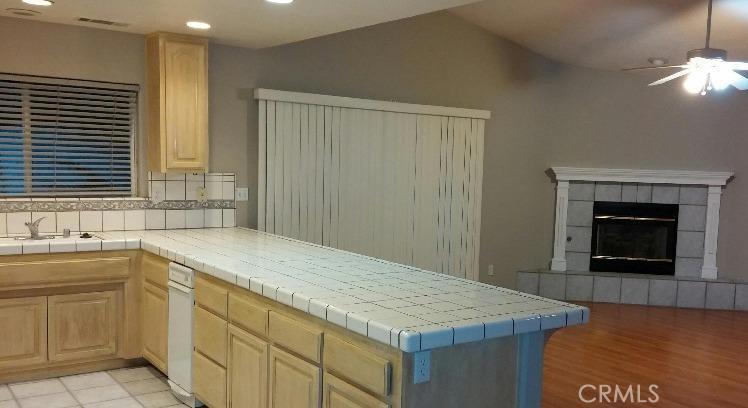 12858 Rain Shadow Road Victorville, CA 92395 - Photo 3 of 15 a kitchen that has a sink and a stove in it