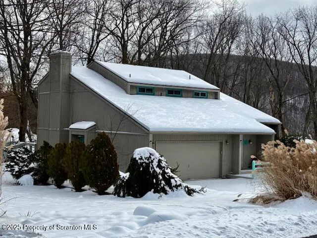 a view of a house with a yard covered in snow