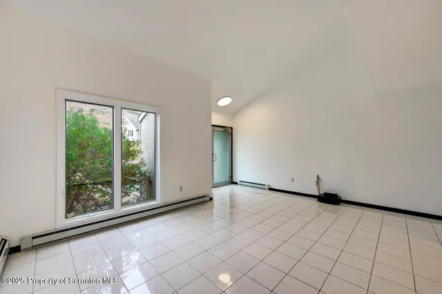 a view of an empty room with a window and a fireplace