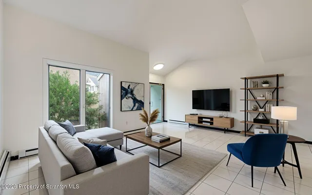 a view of a hallway with wooden floor and a living room