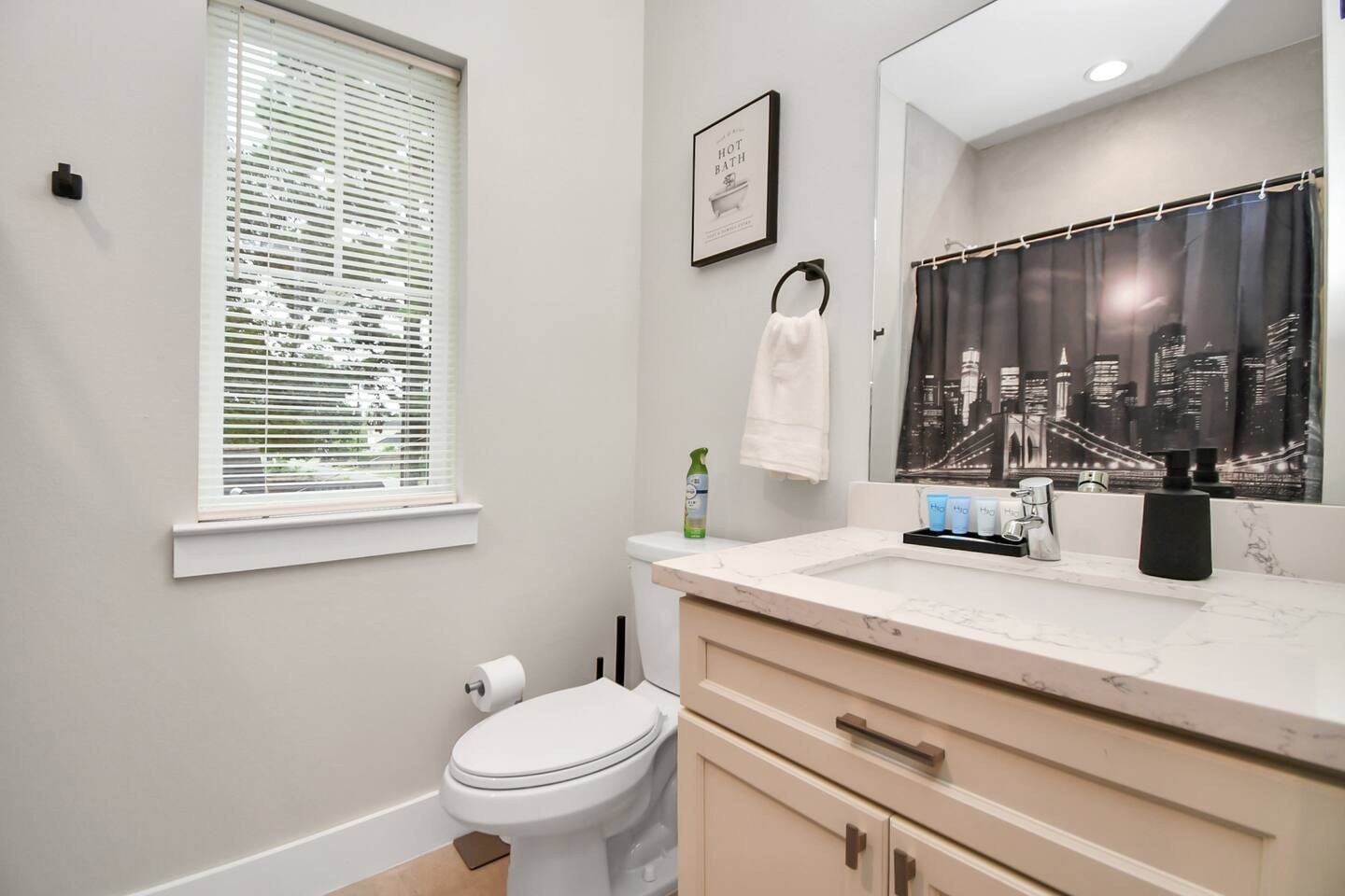 5718 Beall Street, Unit D Houston, TX 77091 - Photo 36 of 41 a bathroom with a granite countertop sink toilet and mirror