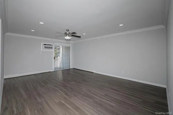 a view of a livingroom with wooden floor and a ceiling fan