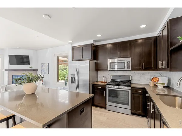a kitchen with kitchen island a counter top space cabinets and living room view