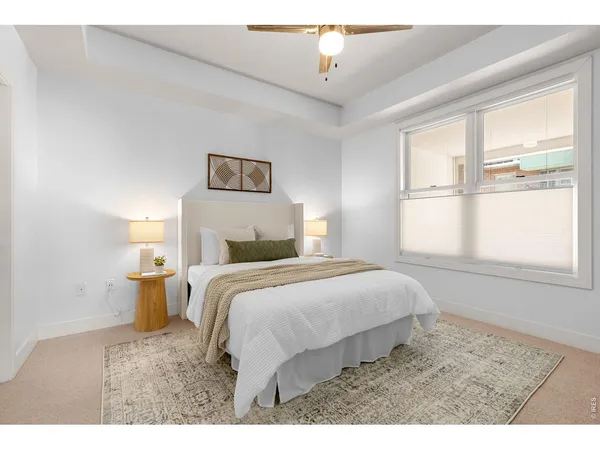 a bedroom with a bed and a large window with mirror